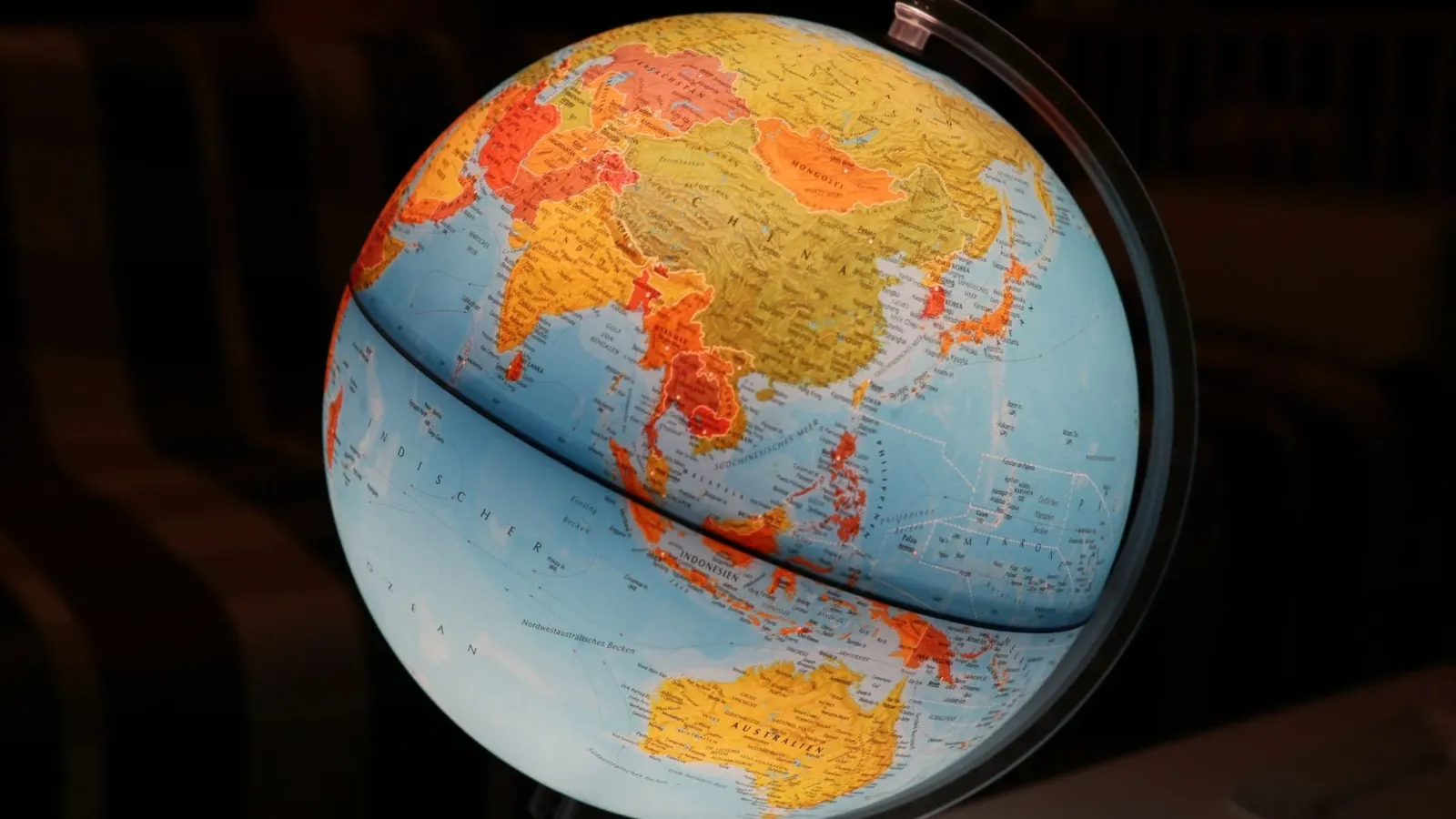 Beleuchteter Globus mit Kontinenten vor dunklem Hintergrund